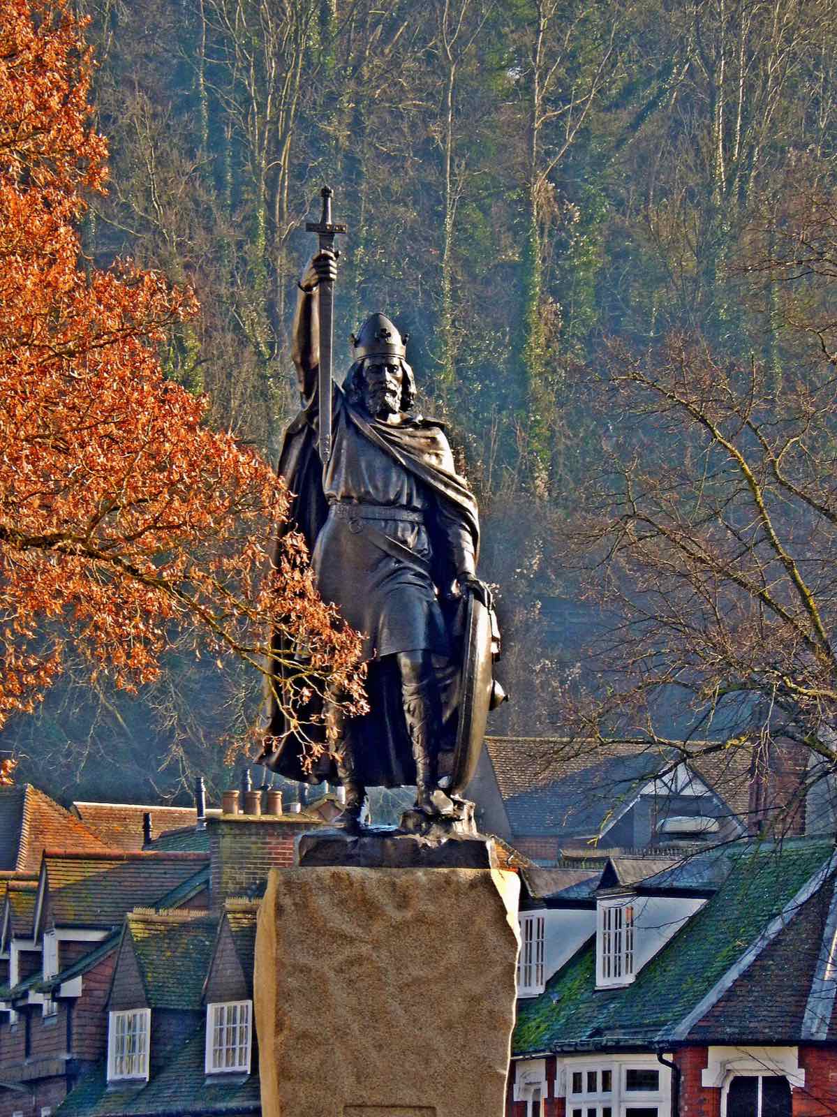 Statua in bronzo di Alfredo il Grande a Winchester, con una spada a forma di croce alzata e uno scudo