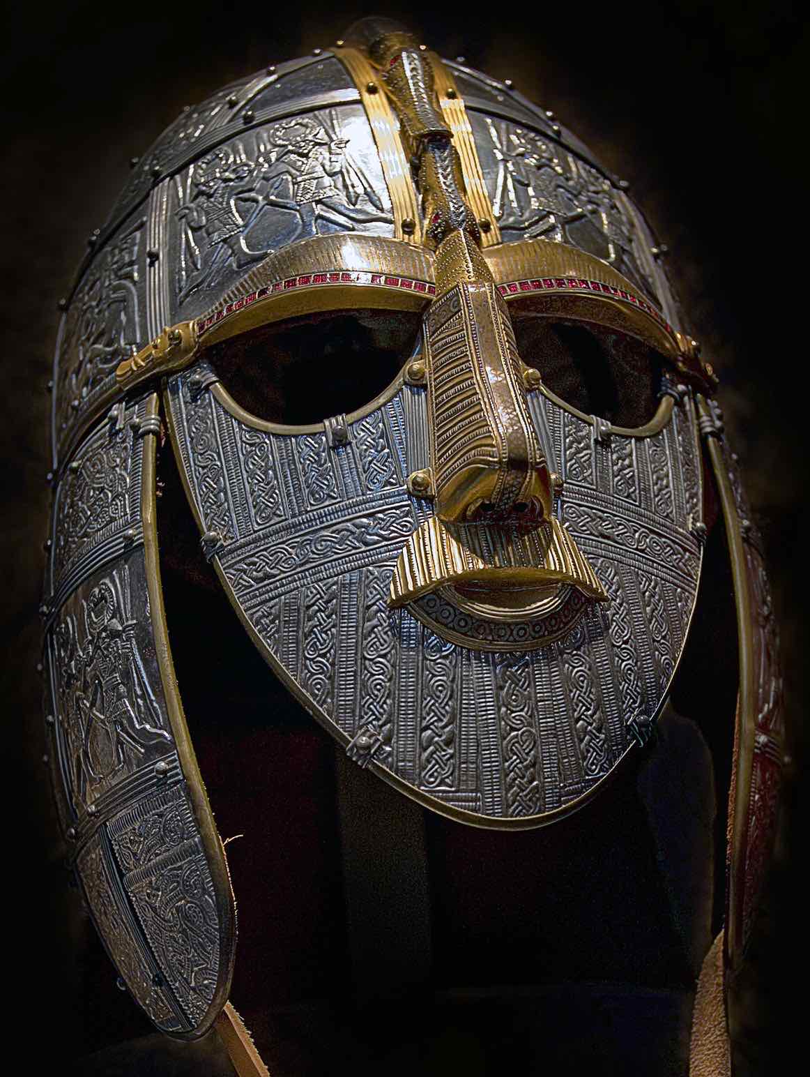 Una replica dell'elmo di Sutton Hoo: un elmo di ferro con una maschera che copre tutto il viso, con sopracciglia e naso decorati in oro